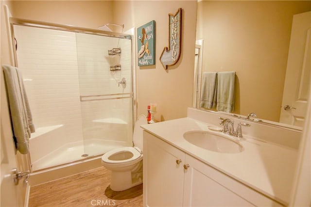 bathroom featuring vanity, toilet, an enclosed shower, and hardwood / wood-style floors