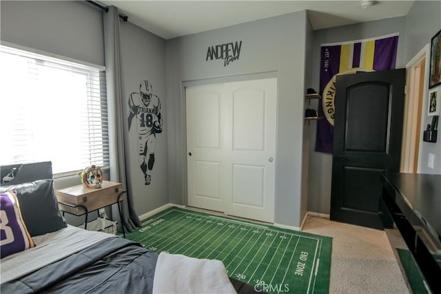 carpeted bedroom featuring multiple windows and a closet