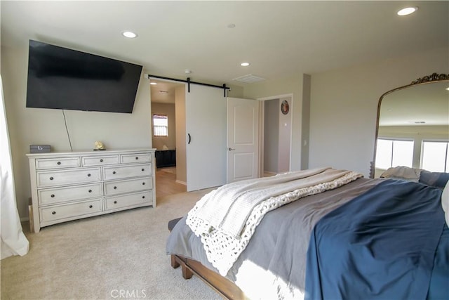 carpeted bedroom featuring a barn door