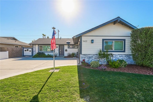 ranch-style home featuring a garage and a front lawn