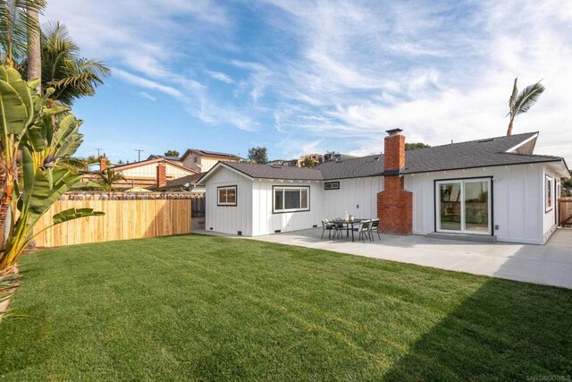 rear view of property with a lawn and a patio