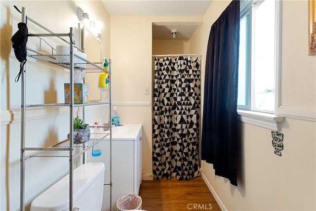 bathroom featuring vanity, hardwood / wood-style flooring, a wealth of natural light, and toilet