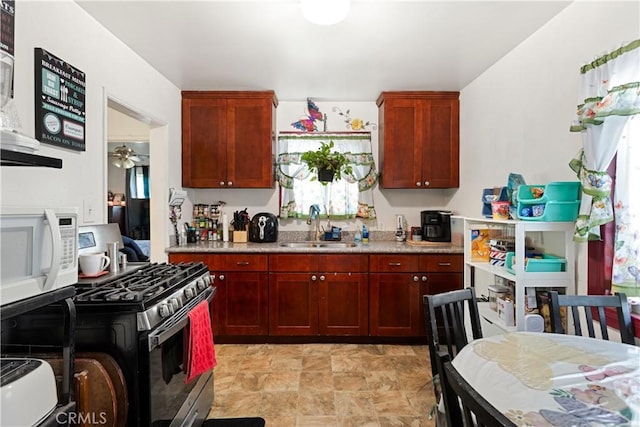 kitchen featuring sink, stainless steel range with gas stovetop, and ceiling fan