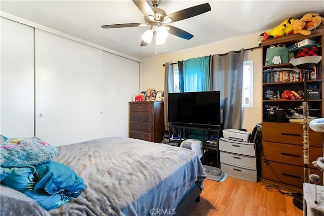 bedroom with a closet, ceiling fan, and light hardwood / wood-style flooring