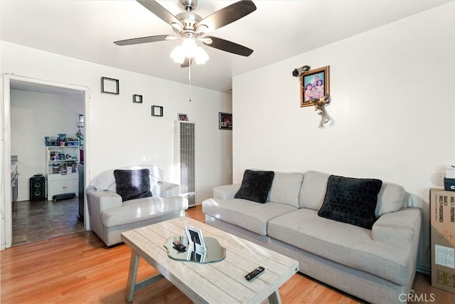 living room featuring wood-type flooring and ceiling fan