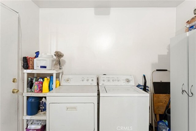 laundry room featuring washing machine and dryer and cabinets