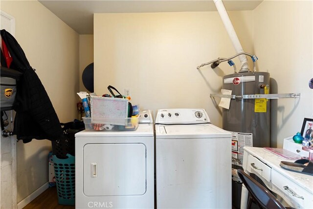 washroom featuring hardwood / wood-style flooring, independent washer and dryer, and strapped water heater