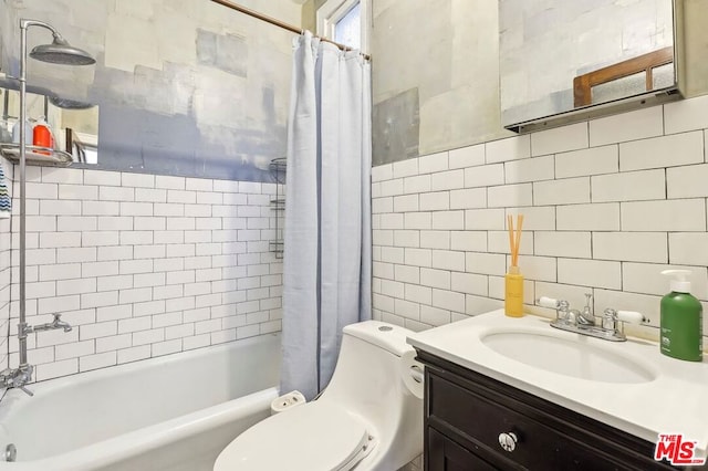 full bathroom with vanity, toilet, tile walls, and shower / bath combo