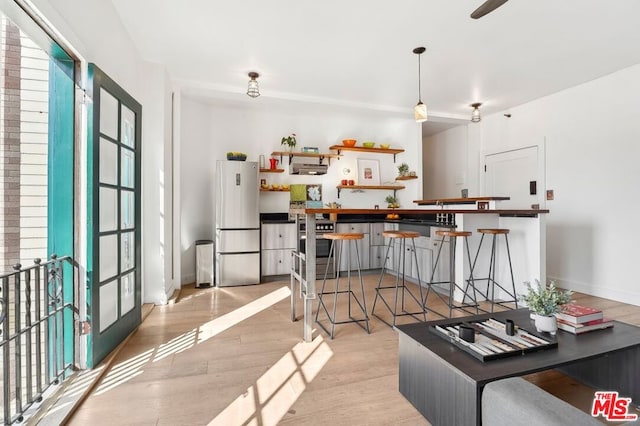 interior space featuring refrigerator and light hardwood / wood-style flooring