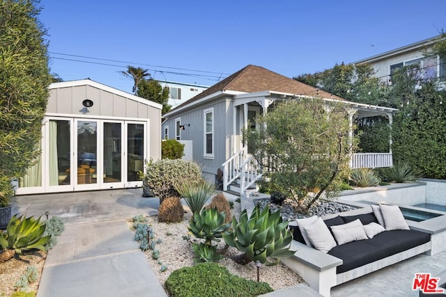 back of house with french doors, outdoor lounge area, and a patio area