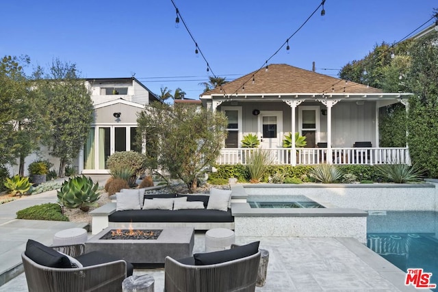 back of property with a porch, an in ground hot tub, and an outdoor living space with a fire pit