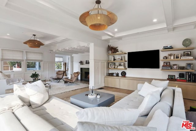 living room with hardwood / wood-style flooring, a fireplace, and beamed ceiling