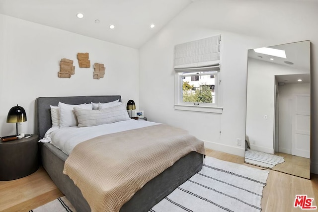 bedroom with lofted ceiling and light hardwood / wood-style floors