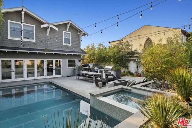 view of swimming pool with an in ground hot tub, a grill, and a patio