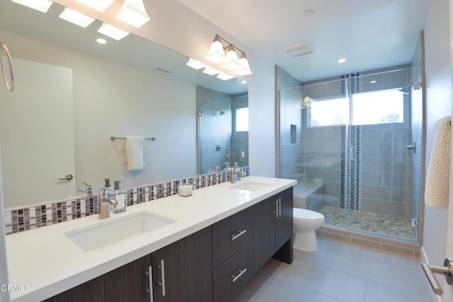 bathroom featuring tasteful backsplash, vanity, a shower with door, and toilet