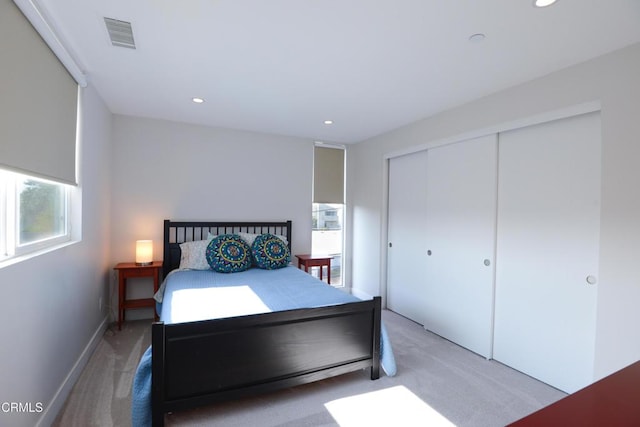 bedroom with a closet and light carpet