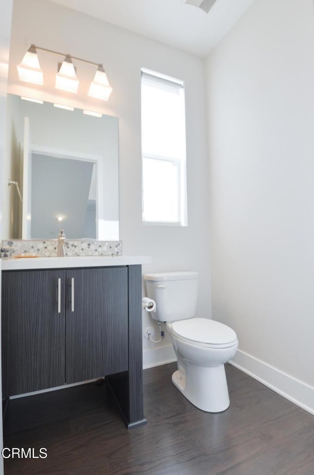 bathroom featuring vanity, wood-type flooring, and toilet