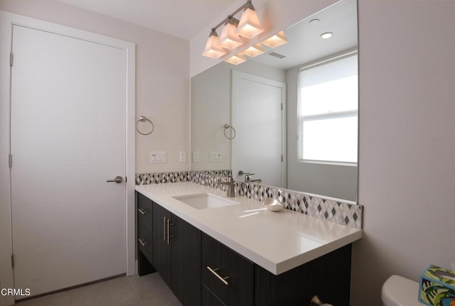 bathroom featuring tile patterned flooring, vanity, and toilet