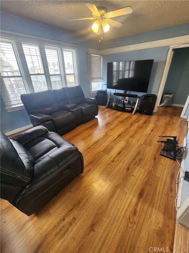 living room featuring hardwood / wood-style floors, a textured ceiling, and ceiling fan