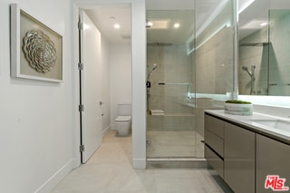 bathroom with vanity, toilet, and a shower with door