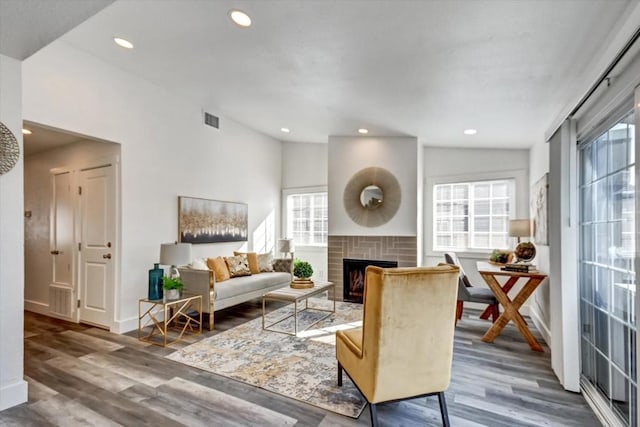 living room featuring dark hardwood / wood-style flooring, vaulted ceiling, and a fireplace