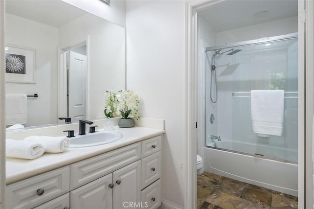 full bathroom featuring enclosed tub / shower combo, vanity, and toilet