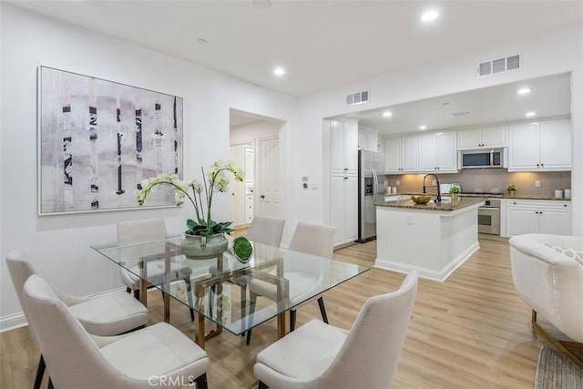 dining space featuring sink and light hardwood / wood-style floors