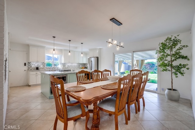 dining area featuring light tile patterned flooring, beverage cooler, a tray ceiling, and an inviting chandelier