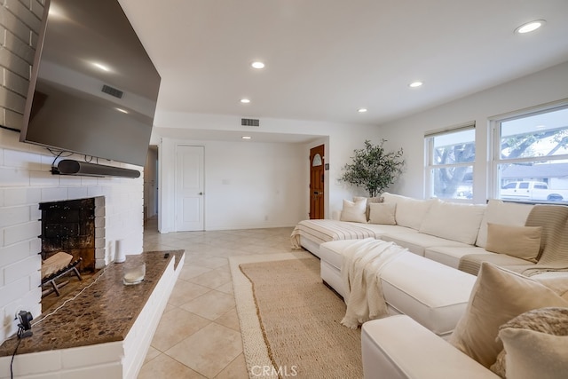 living room with light tile patterned floors and a fireplace