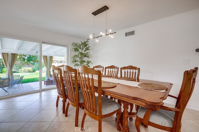 tiled dining space with a chandelier