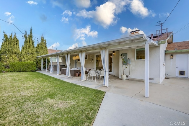 rear view of property with a yard and a patio area