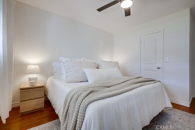 bedroom with dark hardwood / wood-style floors and ceiling fan