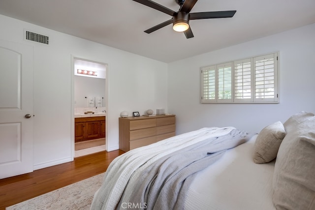 bedroom with hardwood / wood-style floors, ceiling fan, and ensuite bathroom