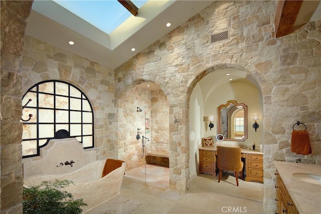 bathroom with beamed ceiling, vanity, tile patterned flooring, and a tub