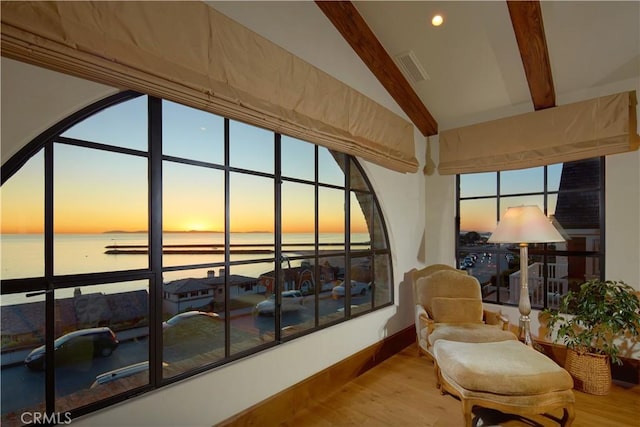 sunroom / solarium with lofted ceiling with beams and a water view