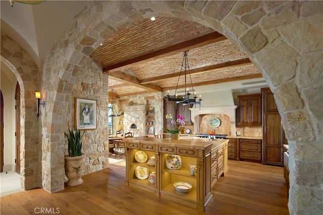 bar featuring pendant lighting, backsplash, brick ceiling, and light wood-type flooring