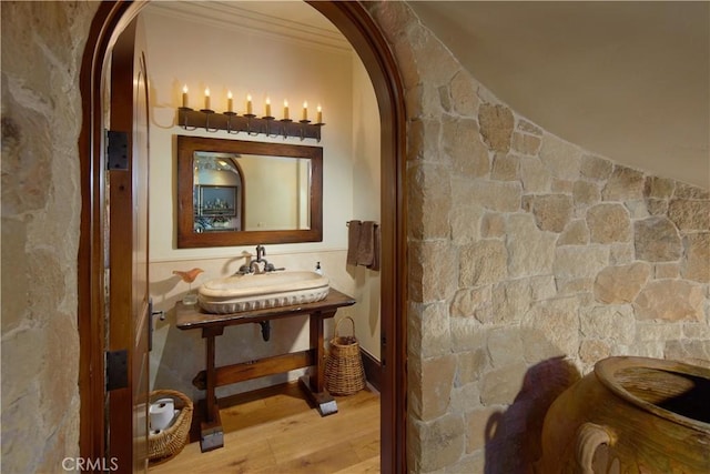 corridor featuring hardwood / wood-style floors, ornamental molding, and sink