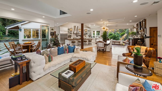 living room with an inviting chandelier and light wood-type flooring