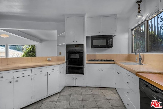 kitchen with light tile patterned flooring, tile countertops, sink, white cabinets, and black appliances