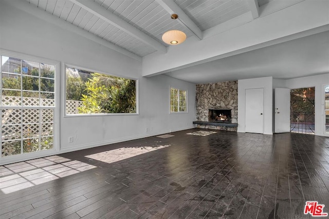 unfurnished living room featuring plenty of natural light, dark wood-type flooring, and a fireplace