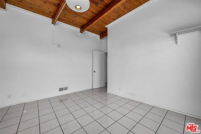 spare room featuring beamed ceiling, light tile patterned floors, and wooden ceiling