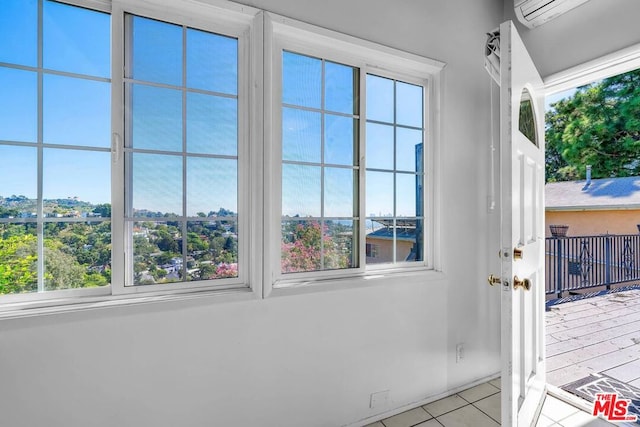 doorway with light tile patterned floors and an AC wall unit