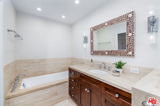 bathroom with vanity, tiled tub, and tile patterned floors