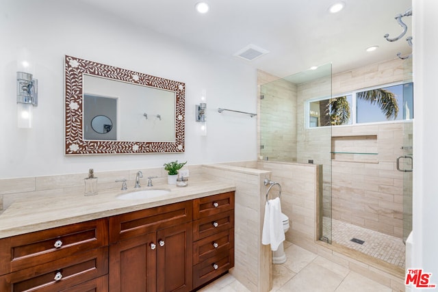 bathroom featuring vanity, a shower with shower door, and tile patterned flooring