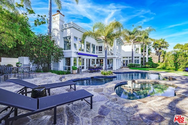 view of swimming pool with an in ground hot tub and a patio area