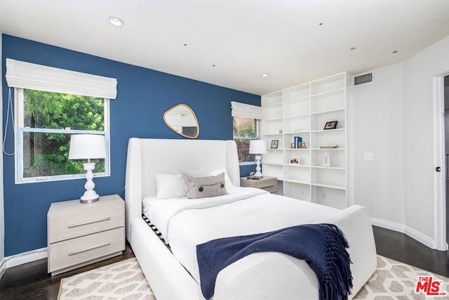 bedroom with dark hardwood / wood-style flooring