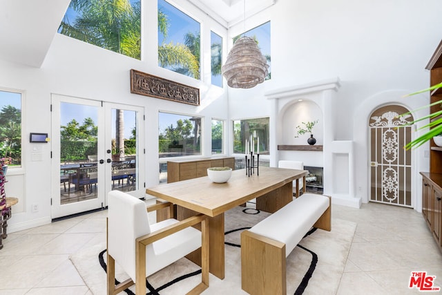 tiled dining room with a towering ceiling and french doors