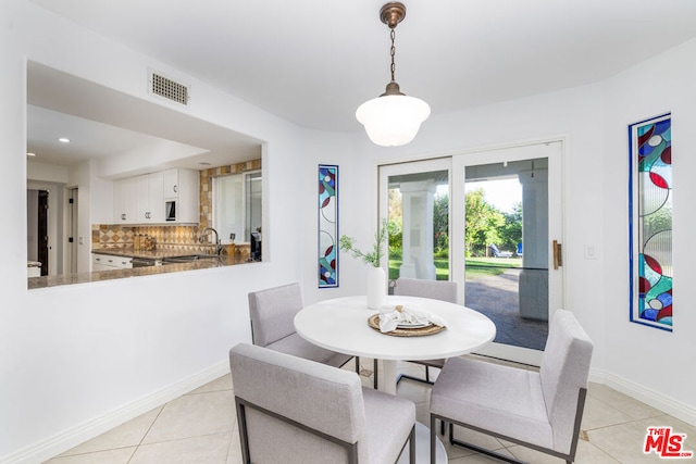 dining area featuring sink and light tile patterned floors