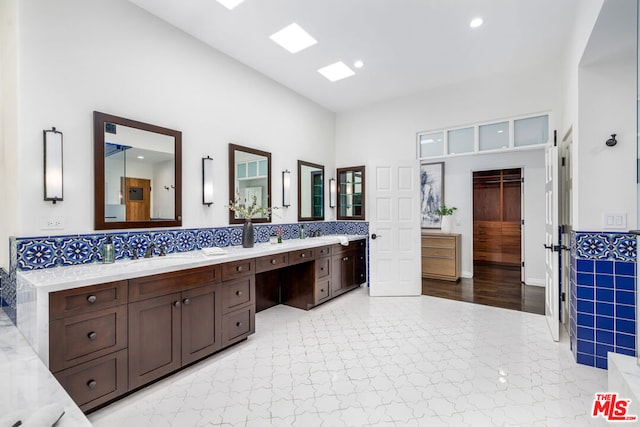 bathroom with a high ceiling, vanity, and backsplash