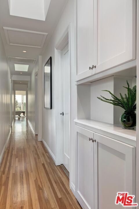 hallway with light hardwood / wood-style floors